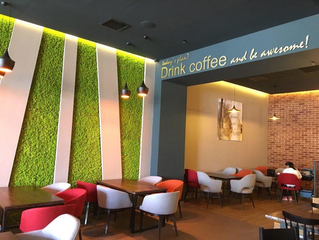 Cafeneaua Gloria Jean's Coffee din Mall Sun Plaza, cu benzi verticale de licheni verde deschis pe peretele sălii