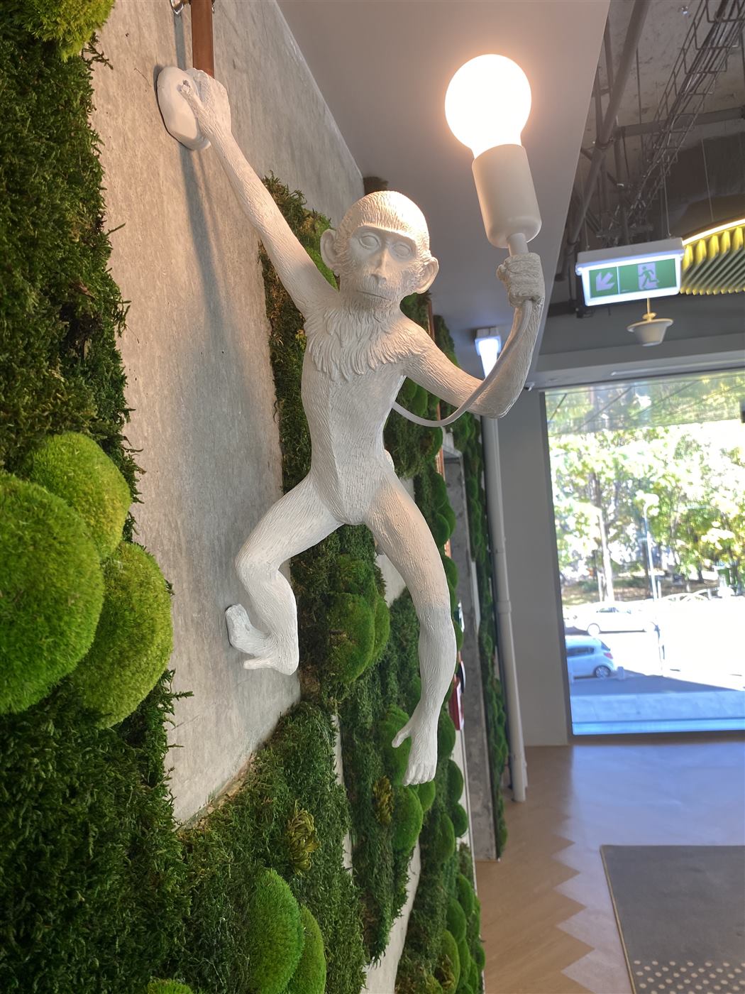Lampă decorativă albă integrată într-un perete din mușchi stabilizat